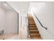 Bright hallway with hardwood floors and staircase featuring modern black railing at 2391 King St, Denver, CO 80211