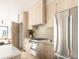 Modern kitchen with stainless steel appliances, light wood cabinetry, and tile backsplash at 2391 King St, Denver, CO 80211