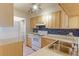 Functional kitchen with light wood cabinets, white appliances, and blue tile backsplash at 6776 S Holland Way, Littleton, CO 80128