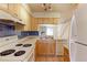 Well-lit kitchen with laminate countertops and white appliances, with an open view to the living area at 6776 S Holland Way, Littleton, CO 80128
