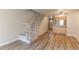 Open-concept living room featuring hardwood floors, staircase, and view of kitchen at 6776 S Holland Way, Littleton, CO 80128