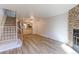 Bright living room with hardwood floors, fireplace, and staircase access at 6776 S Holland Way, Littleton, CO 80128