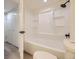 Clean bathroom with a shower-tub combo featuring built-in shelves and modern fixtures at 4691 S Decatur St # 215, Englewood, CO 80110