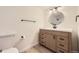 Updated bathroom with a modern vanity, round mirror, stylish lighting, and neutral color palette at 4691 S Decatur St # 215, Englewood, CO 80110