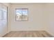 Bright bedroom featuring a window view, wood-look flooring, and white walls and trim at 4691 S Decatur St # 215, Englewood, CO 80110