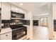 Updated kitchen with stainless appliances, dark backsplash, and open view to living room at 4691 S Decatur St # 215, Englewood, CO 80110