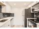 Modern kitchen with white cabinets, stainless steel appliances, and a stylish backsplash at 4691 S Decatur St # 215, Englewood, CO 80110