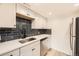 Modern kitchen with white cabinets, stainless steel appliances, and a stylish backsplash at 4691 S Decatur St # 215, Englewood, CO 80110