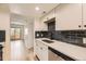 Updated kitchen with stainless appliances, dark backsplash, and open view to living room at 4691 S Decatur St # 215, Englewood, CO 80110