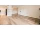 Open-concept living room with light hardwood floors, and a view of the kitchen and dining area at 4691 S Decatur St # 215, Englewood, CO 80110