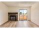 Living room featuring a stone fireplace, light-colored hardwood floors, and sliding door to the balcony at 4691 S Decatur St # 215, Englewood, CO 80110