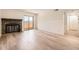 Living room featuring a stone fireplace, light-colored hardwood floors, and access to the balcony at 4691 S Decatur St # 215, Englewood, CO 80110