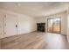 Living room with stone fireplace, light hardwood flooring, and a sliding door to the balcony at 4691 S Decatur St # 215, Englewood, CO 80110