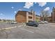 An exterior shot of a brown building with parking for residents and a stone facade at 4691 S Decatur St # 215, Englewood, CO 80110