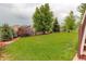 Spacious green backyard with mature landscaping, a white fence, and a lush lawn, great for outdoor activities at 5528 Echo Hollow St, Castle Rock, CO 80104