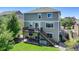 Two-story home with a large deck and backyard featuring lush green grass and mature trees at 5528 Echo Hollow St, Castle Rock, CO 80104
