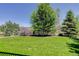 Wide shot of the home's backyard featuring a well-kept lawn, landscaping, and a white fence line at 5528 Echo Hollow St, Castle Rock, CO 80104