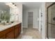 Bathroom with double sinks, wood cabinets, tile floors and a glass enclosed shower at 5528 Echo Hollow St, Castle Rock, CO 80104