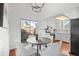 Bright dining area with wood table, white chairs, and sliding glass door to outdoor patio at 1248 W 135Th Ave, Denver, CO 80234