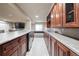 Finished basement bar features cherry cabinets, grey countertops, stainless steel fridge, and tile flooring at 8533 S Flower Ct, Littleton, CO 80128