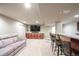 Finished basement with seating, built-in bar, and large screen TV with storage at 8533 S Flower Ct, Littleton, CO 80128