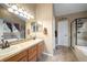 Well lit bathroom with double vanity, soaking tub, and separate shower with tile flooring at 8533 S Flower Ct, Littleton, CO 80128