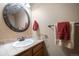 Half bathroom features a round mirror and decorative fixtures at 8533 S Flower Ct, Littleton, CO 80128