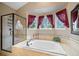 Modern bathroom features separate shower, soaking tub and large windows with privacy curtains at 8533 S Flower Ct, Littleton, CO 80128