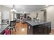 Open-concept kitchen and living room with hardwood floors, granite countertops, and stainless steel appliances at 8533 S Flower Ct, Littleton, CO 80128