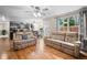 Bright living room showcasing hardwood floors, large windows, and an open view to the kitchen at 8533 S Flower Ct, Littleton, CO 80128