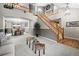 Open-concept living room with a grand staircase, adjacent dining area, and neutral decor at 8533 S Flower Ct, Littleton, CO 80128