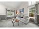 Cozy living room with plush seating, and natural light from two large windows at 8533 S Flower Ct, Littleton, CO 80128