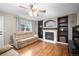 Cozy living room featuring hardwood floors, a ceiling fan, a fireplace and built-in shelving at 8533 S Flower Ct, Littleton, CO 80128