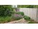 Landscaped backyard featuring a stone retaining wall, colorful flowers, and a wooden fence at 5126 S Malaya Way, Centennial, CO 80015