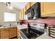Stainless steel oven and cooktop with light wood cabinets and a red backsplash at 5126 S Malaya Way, Centennial, CO 80015