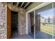 Balcony featuring additional storage unit, stone accent wall, and sliding door access to the living space at 8843 Colorado Blvd # 208, Thornton, CO 80229