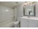 Clean bathroom featuring a tub with shower, white vanity, and decorative framed mirror at 8843 Colorado Blvd # 208, Thornton, CO 80229