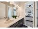 Modern bathroom with double sinks, dark cabinets, and a view into the adjacent bedroom at 3981 Old Oaks St, Castle Rock, CO 80104