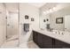 Bright bathroom with a double sink vanity, a mirror with vanity lights, and a walk-in shower in the background at 3981 Old Oaks St, Castle Rock, CO 80104