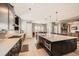 Open kitchen with dark cabinets, stainless steel appliances, a large island, and an open layout to the dining area at 3981 Old Oaks St, Castle Rock, CO 80104