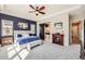 Large main bedroom with modern furniture, a fireplace, and bathroom access through a stylish barn door at 3981 Old Oaks St, Castle Rock, CO 80104