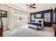 Spacious main bedroom featuring a tray ceiling, a large bed with bench, and windows with natural light at 3981 Old Oaks St, Castle Rock, CO 80104