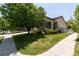 Landscaped corner lot with lush green lawn, mature trees, and decorative white picket fence at 24664 E Louisiana Cir, Aurora, CO 80018