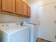 Functional laundry area features a washer, dryer, and storage cabinets at 24664 E Louisiana Cir, Aurora, CO 80018