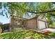 Charming two-story home featuring a brick facade, covered porch, three-car garage, and landscaped front yard at 9638 Marion Way, Thornton, CO 80229
