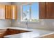 Kitchen featuring a stainless steel sink, light countertops, and wood cabinets at 9638 Marion Way, Thornton, CO 80229