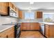 Functional kitchen with wood cabinetry and modern appliances at 9638 Marion Way, Thornton, CO 80229