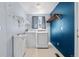 Functional laundry room with washer, dryer, sink, and storage shelves at 9638 Marion Way, Thornton, CO 80229