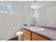 Cozy powder room with a single vanity, toilet, and a window for natural light at 9638 Marion Way, Thornton, CO 80229