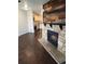 Cozy living space highlighting a rustic stone fireplace and decorative wood mantle, adjacent to a modern kitchen at 185 S Sable Blvd # T18, Aurora, CO 80012